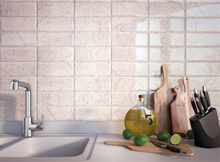 A kitchen counter with a sink , cutting boards , knives and limes.