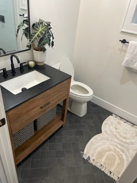 A bathroom with a sink a toilet and a rug