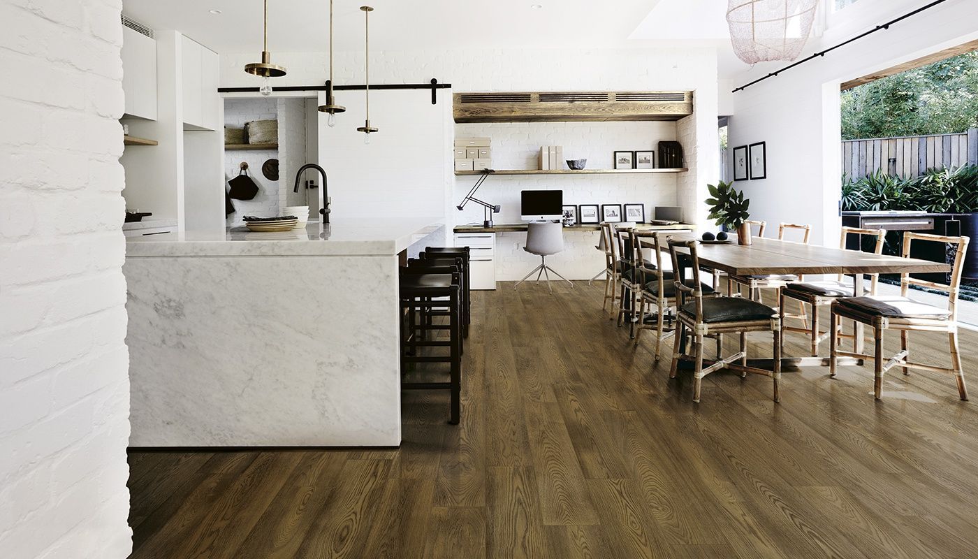 A kitchen and dining room with wooden floors and white walls.