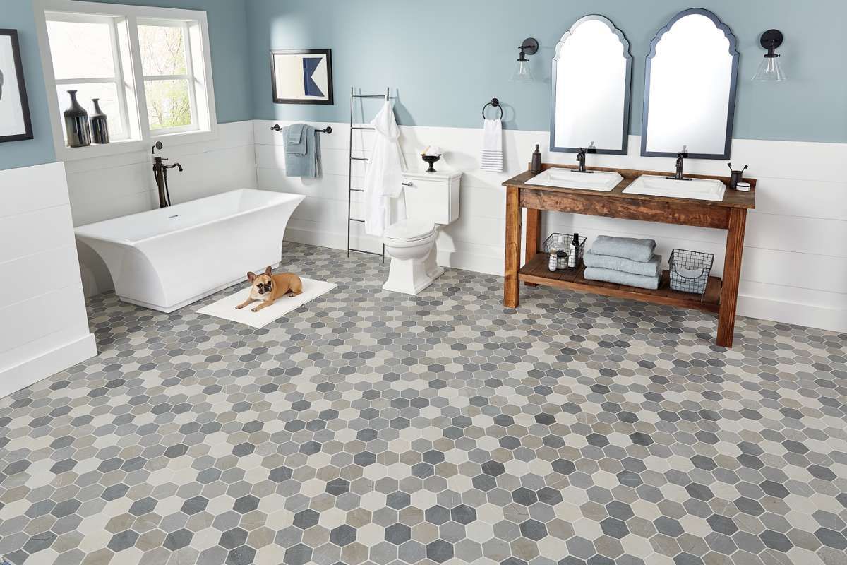 A bathroom with a tub , toilet , sink and mirrors.