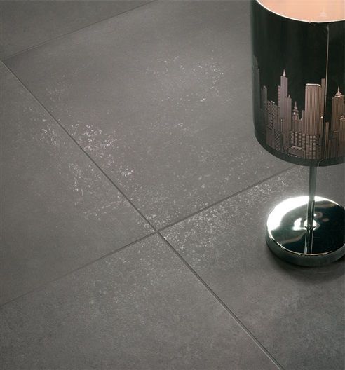 A lamp with a city skyline on it sits on a tiled floor