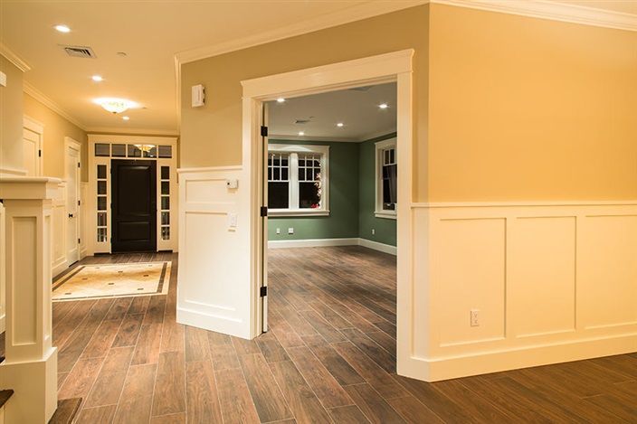 A hallway in a house with hardwood floors and a fireplace.