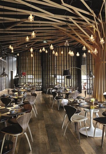 A restaurant with tables and chairs and a tree shaped ceiling