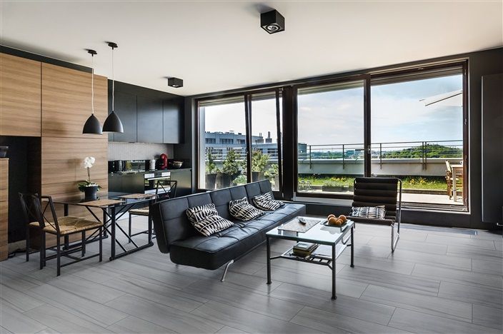 A living room with a couch , table , chairs and a balcony.