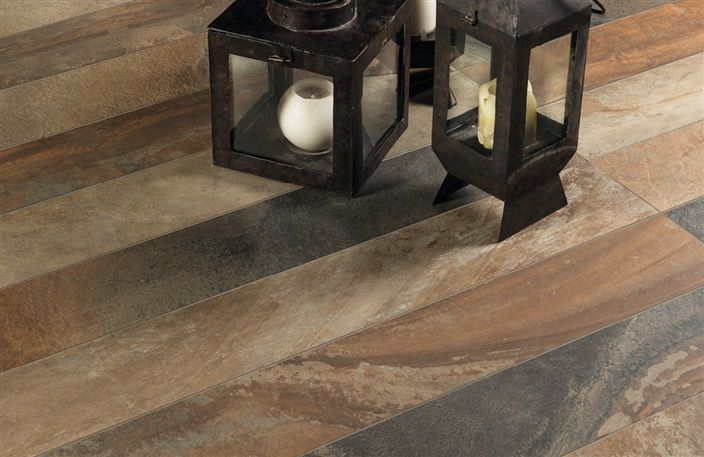 Two lanterns are sitting on a wooden floor.