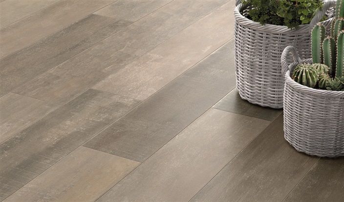 Two baskets filled with plants are sitting on a wooden floor.