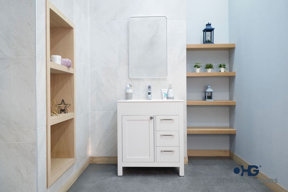 A bathroom with a white vanity , mirror , and shelves.