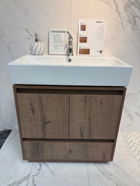 A bathroom sink with a wooden cabinet underneath it