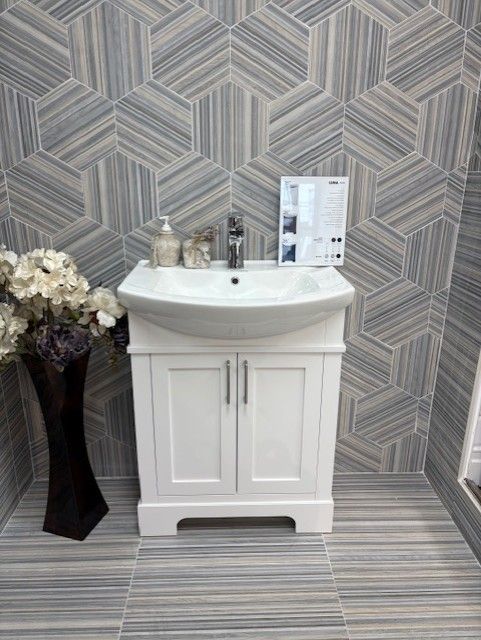 A bathroom with a sink and a vase of flowers.