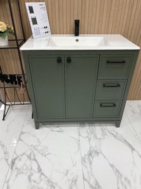 A bathroom vanity with a sink and drawers is sitting on a marble floor.