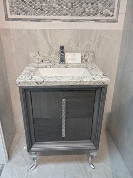 A bathroom vanity with a sink and a faucet on top of it.