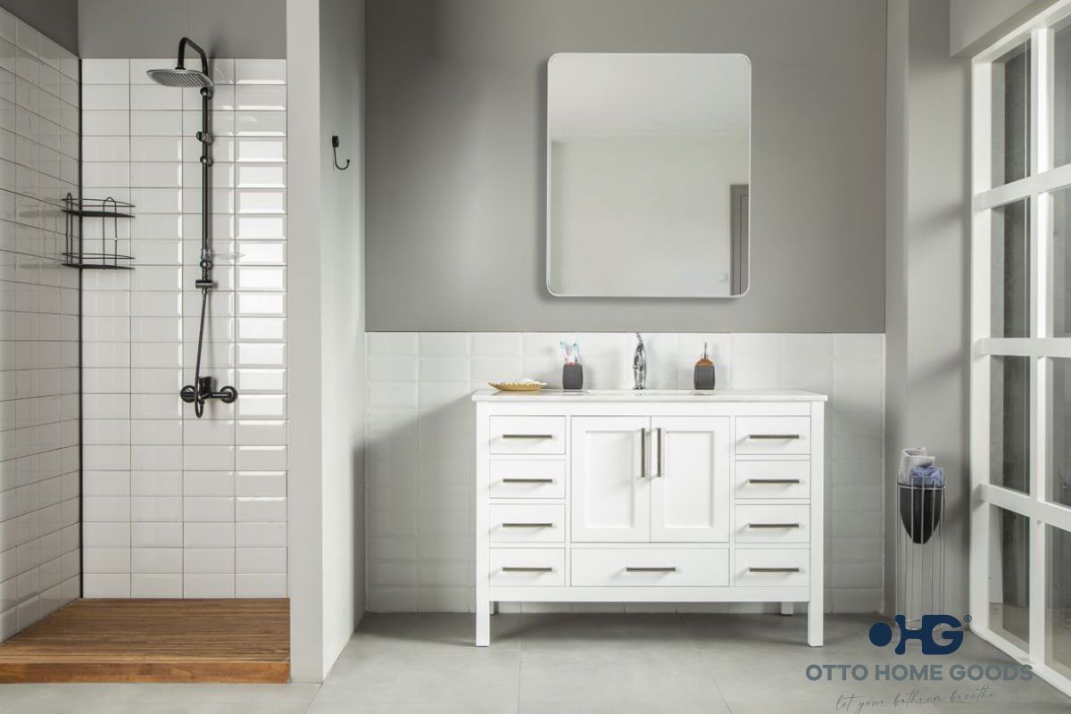 A bathroom with a white vanity , mirror and shower.