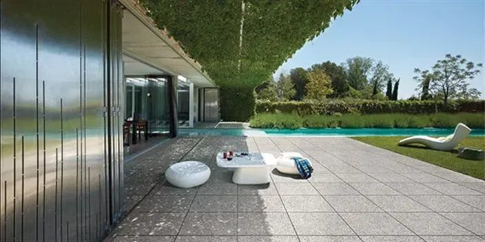 A patio with a table and chairs next to a swimming pool.