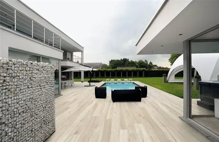 A large white house with a swimming pool in the backyard.