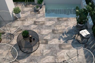 An aerial view of a patio with chairs , a table and a pool.