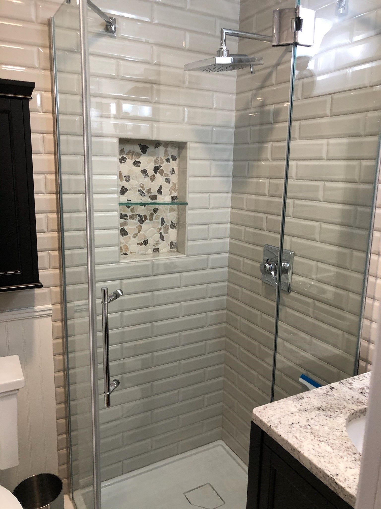 A bathroom with a walk in shower and a sink.