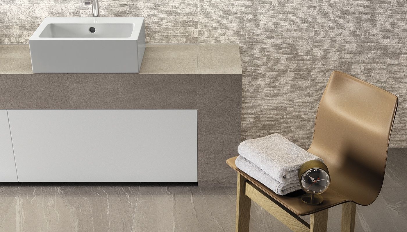 A bathroom with a sink and a chair with towels on it.