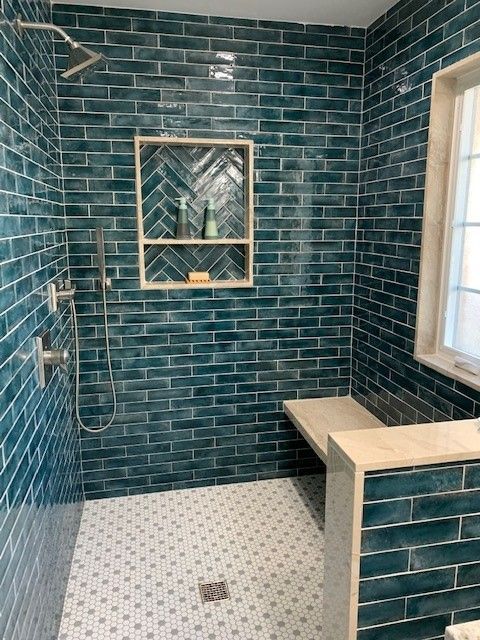 A bathroom with a walk in shower and a bench.