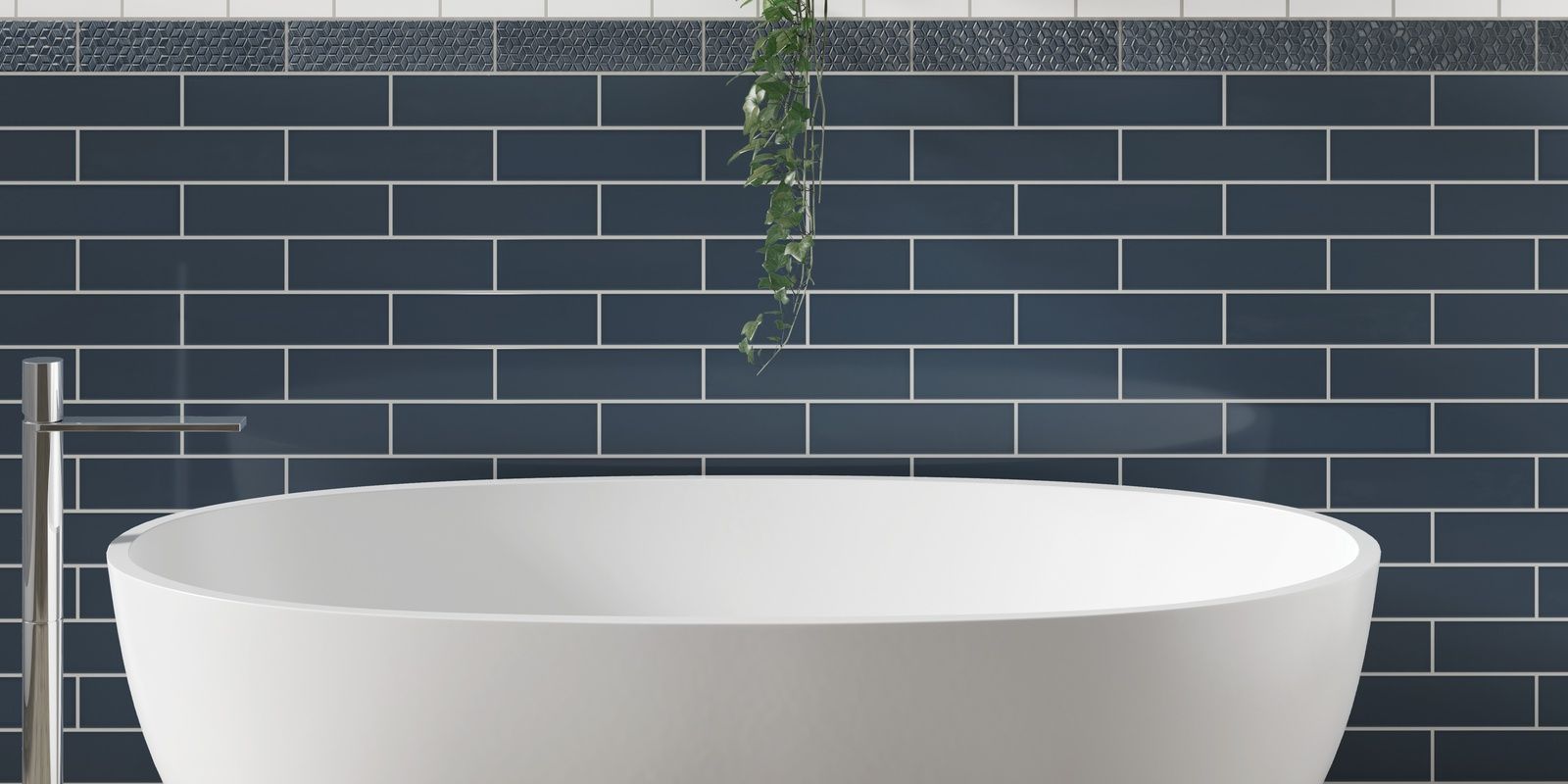 A white bathtub in a bathroom with blue tiles on the wall.