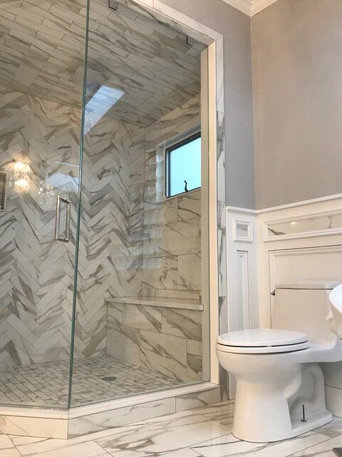 A bathroom with a toilet and a shower with a glass door.