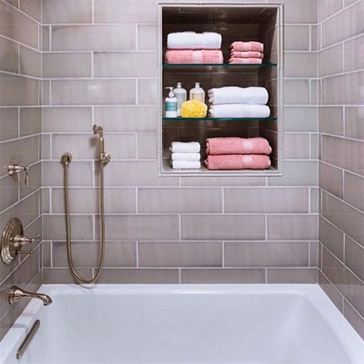 A bathroom with a tub and a shelf full of towels