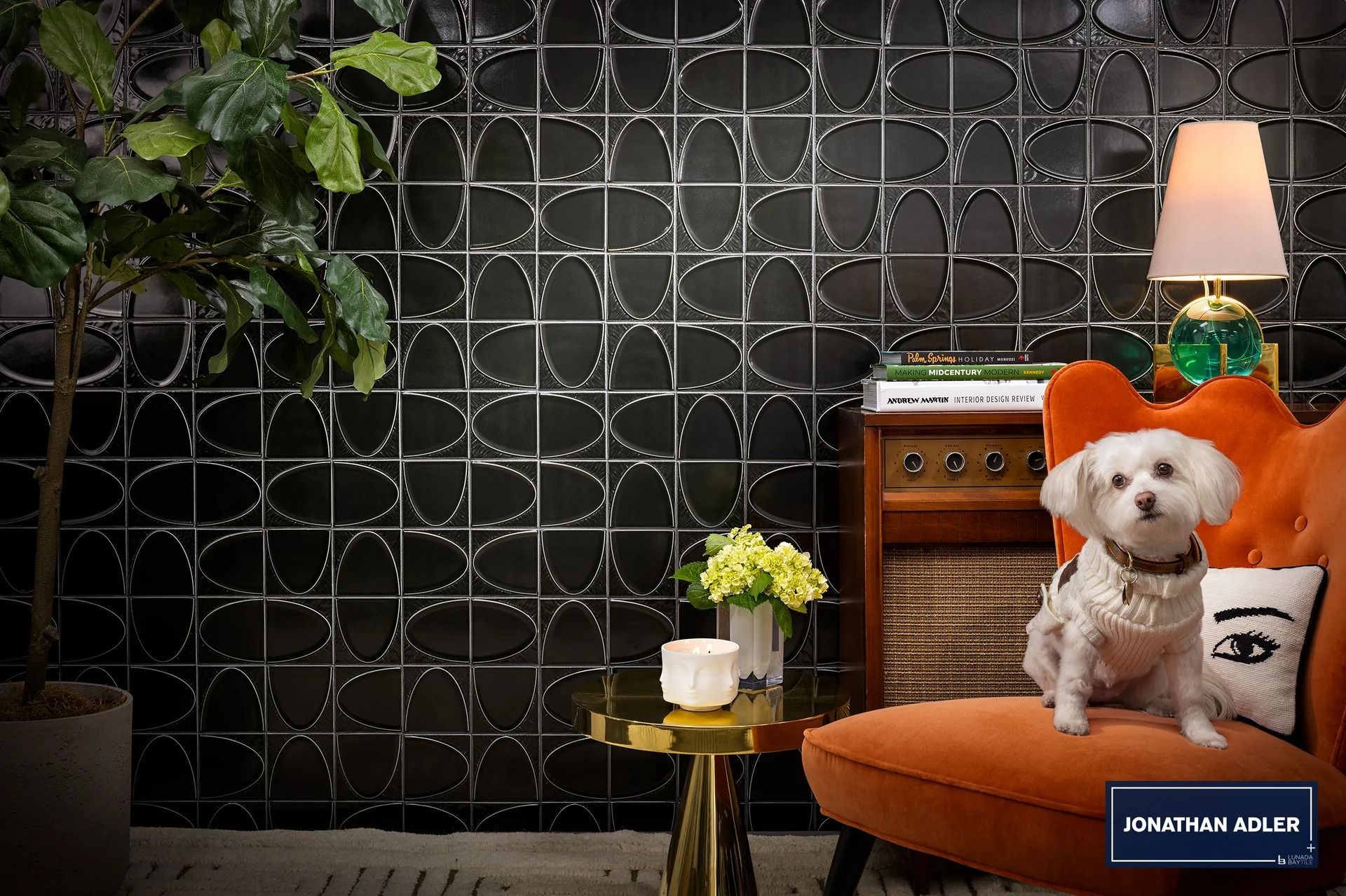 A small white dog is sitting on an orange chair in a living room.