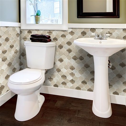 A bathroom with a toilet a sink and a mirror