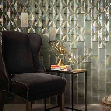 A chair is sitting next to a table in front of a wall with tiles.
