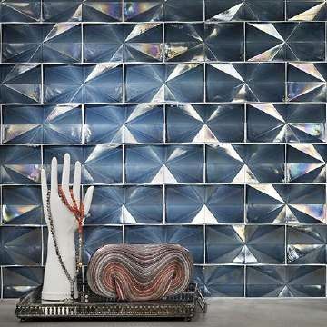 There is a tray with a necklace and a purse on it in front of a wall tile.