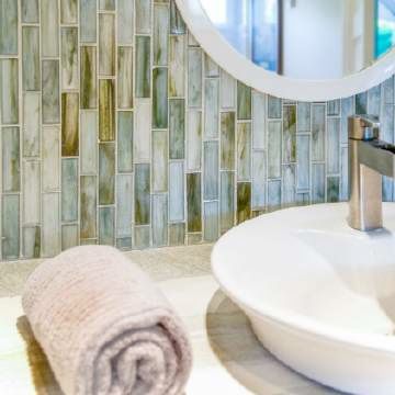 A bathroom sink with a towel and a mirror.