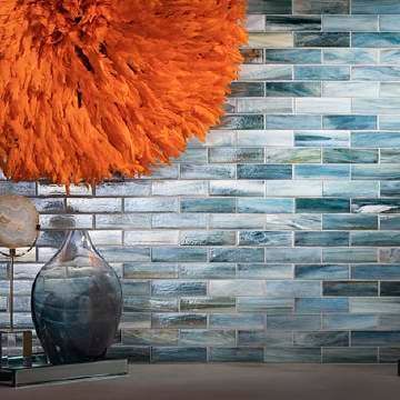 A lamp is sitting on a table in front of a tiled wall.