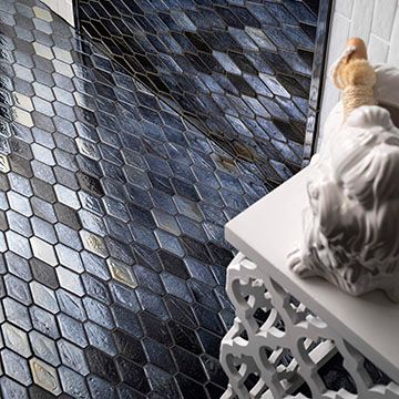 A statue of a cat is sitting on a table next to a tiled floor.
