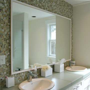 A bathroom with two sinks and a large mirror.