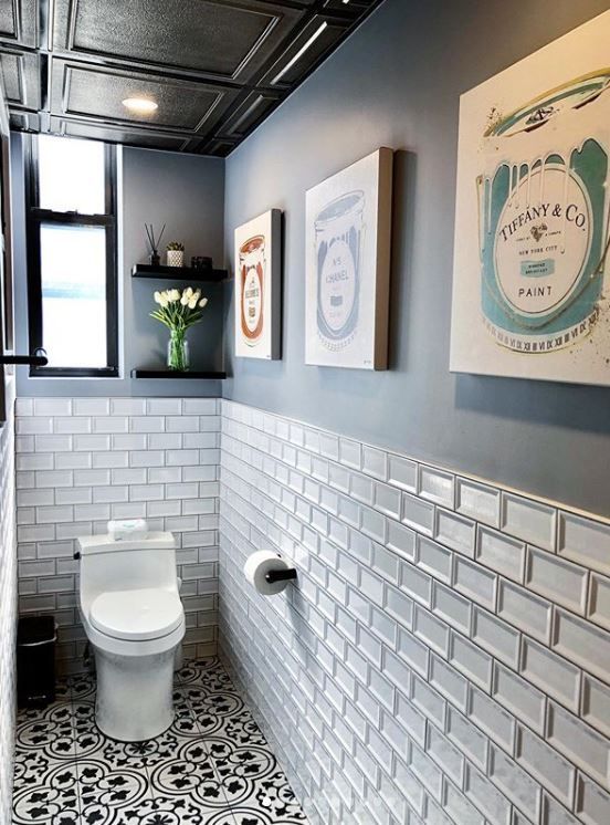 A bathroom with a toilet and a painting on the wall