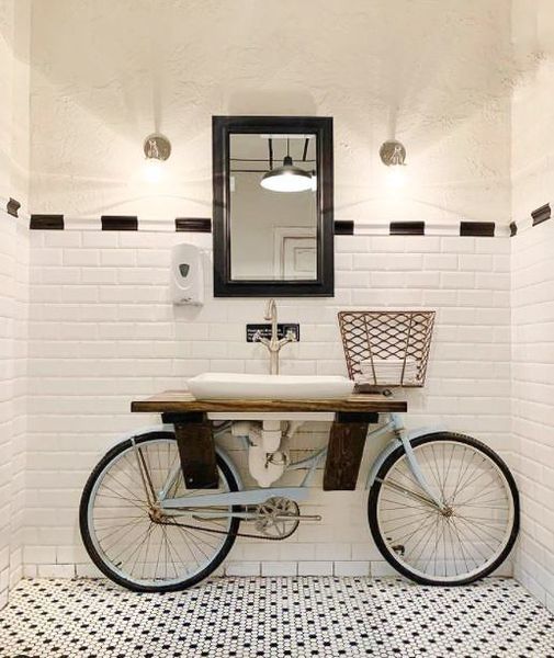 A bathroom with a bicycle attached to a sink