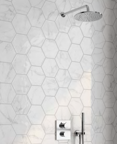 A shower head is hanging from a white tiled wall.