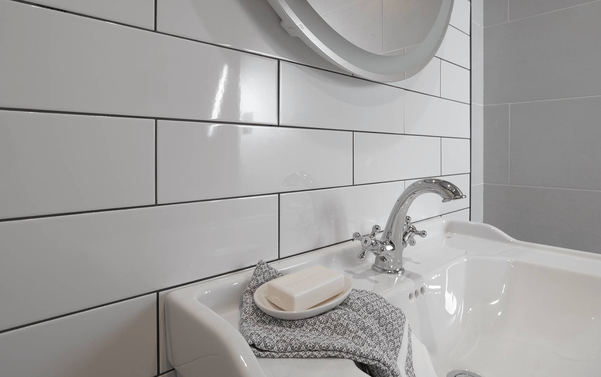 A bathroom sink with a soap bar on it and a mirror.