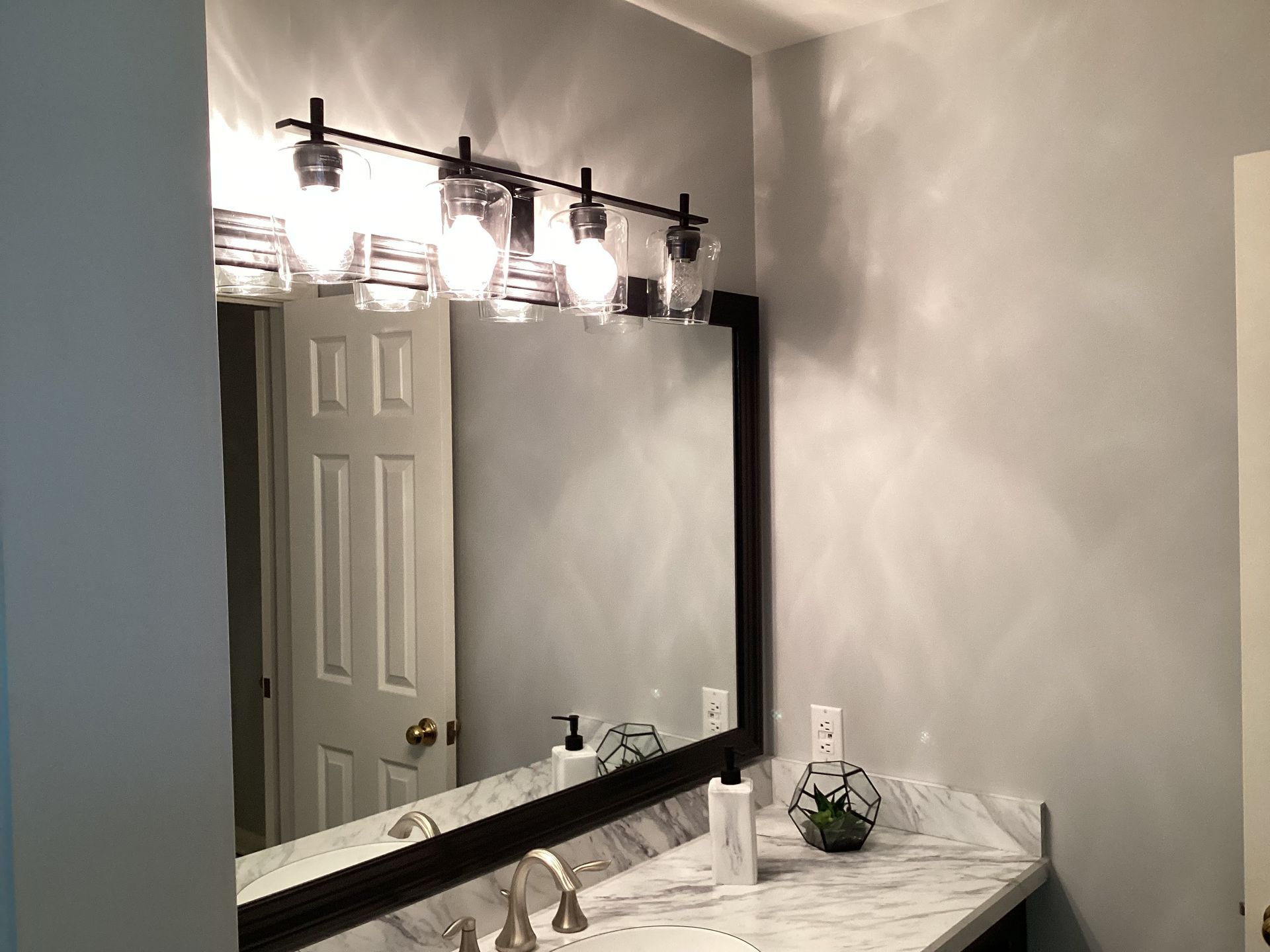 Bathroom with a mirror, vanity, and overhead light fixture.
