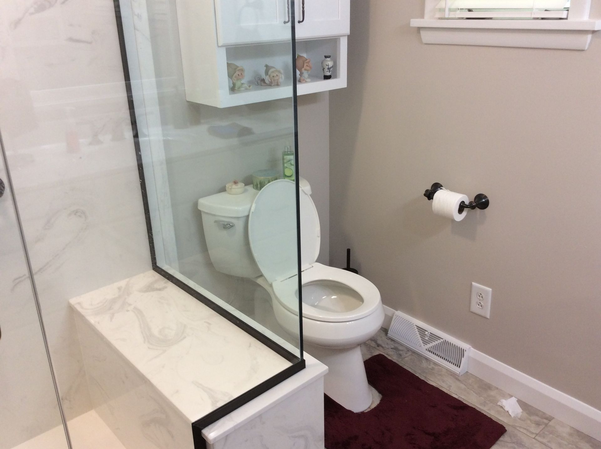 Bathroom interior with a white toilet, shower, and tissue paper roll.