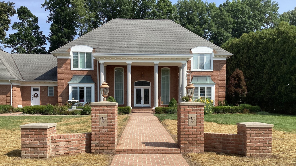 Spacious white kitchen with dark wood island, stainless steel appliances, and hardwood floors.