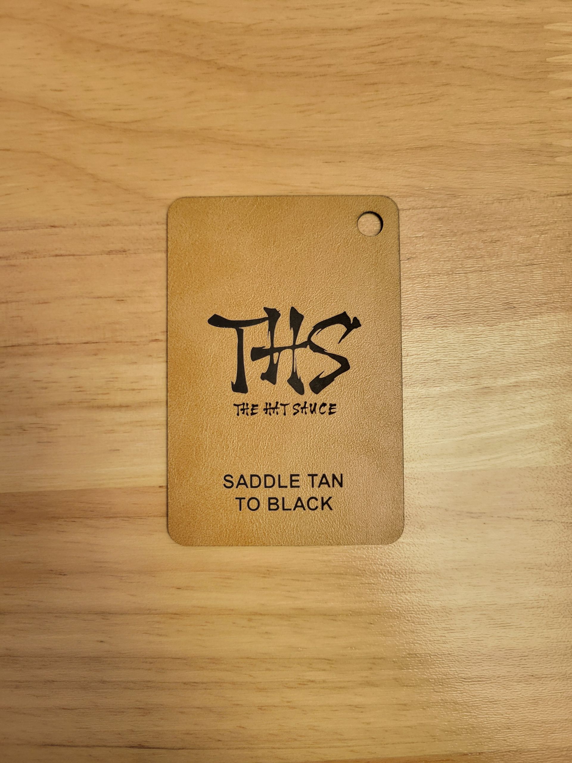 A tag is sitting on top of a wooden table.