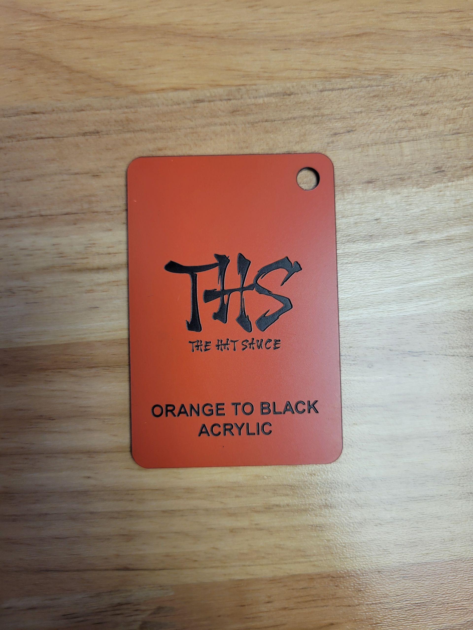 A tag that says orange to black acrylic on it