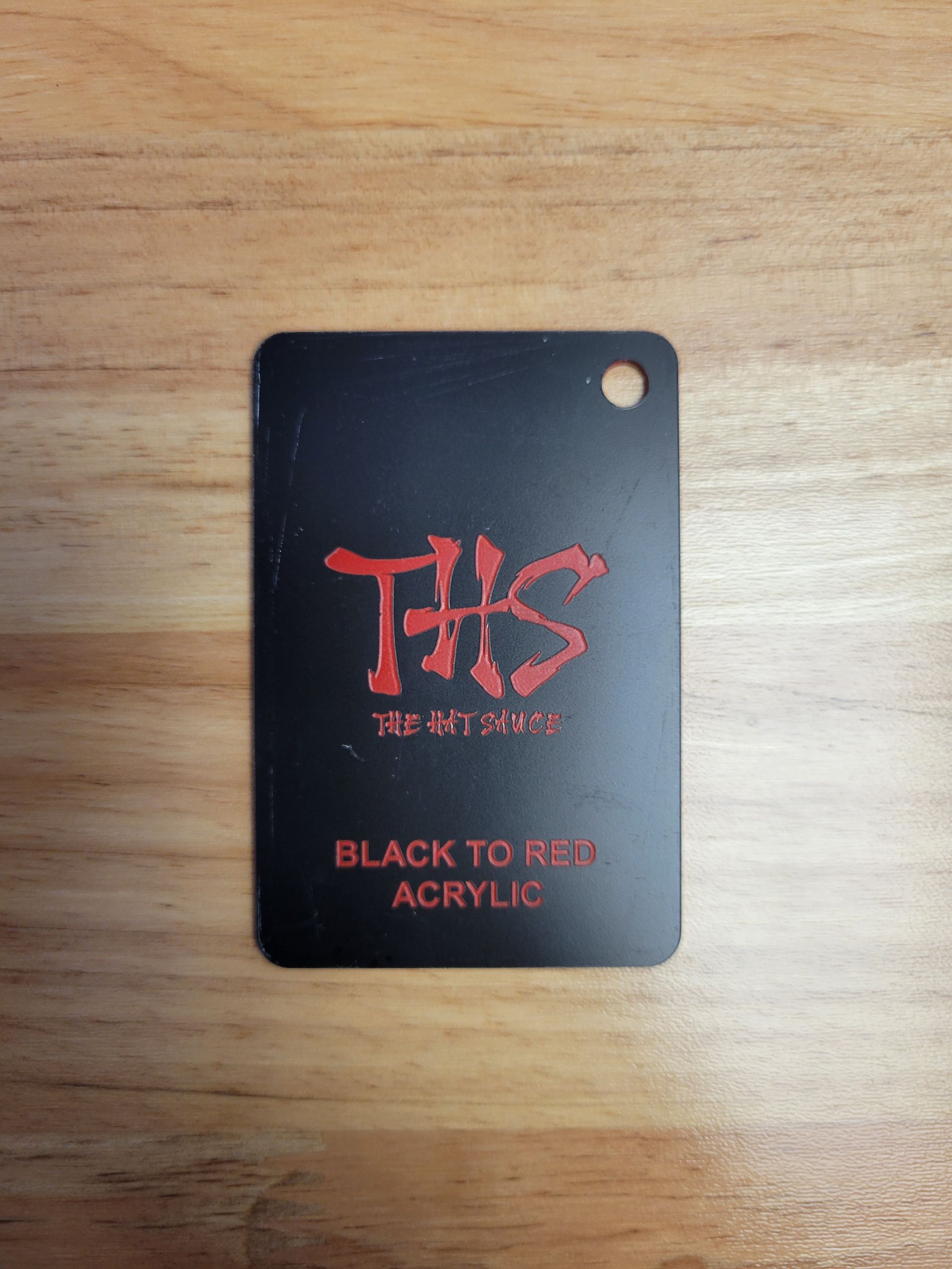 A black tag that says ths black to red acrylic