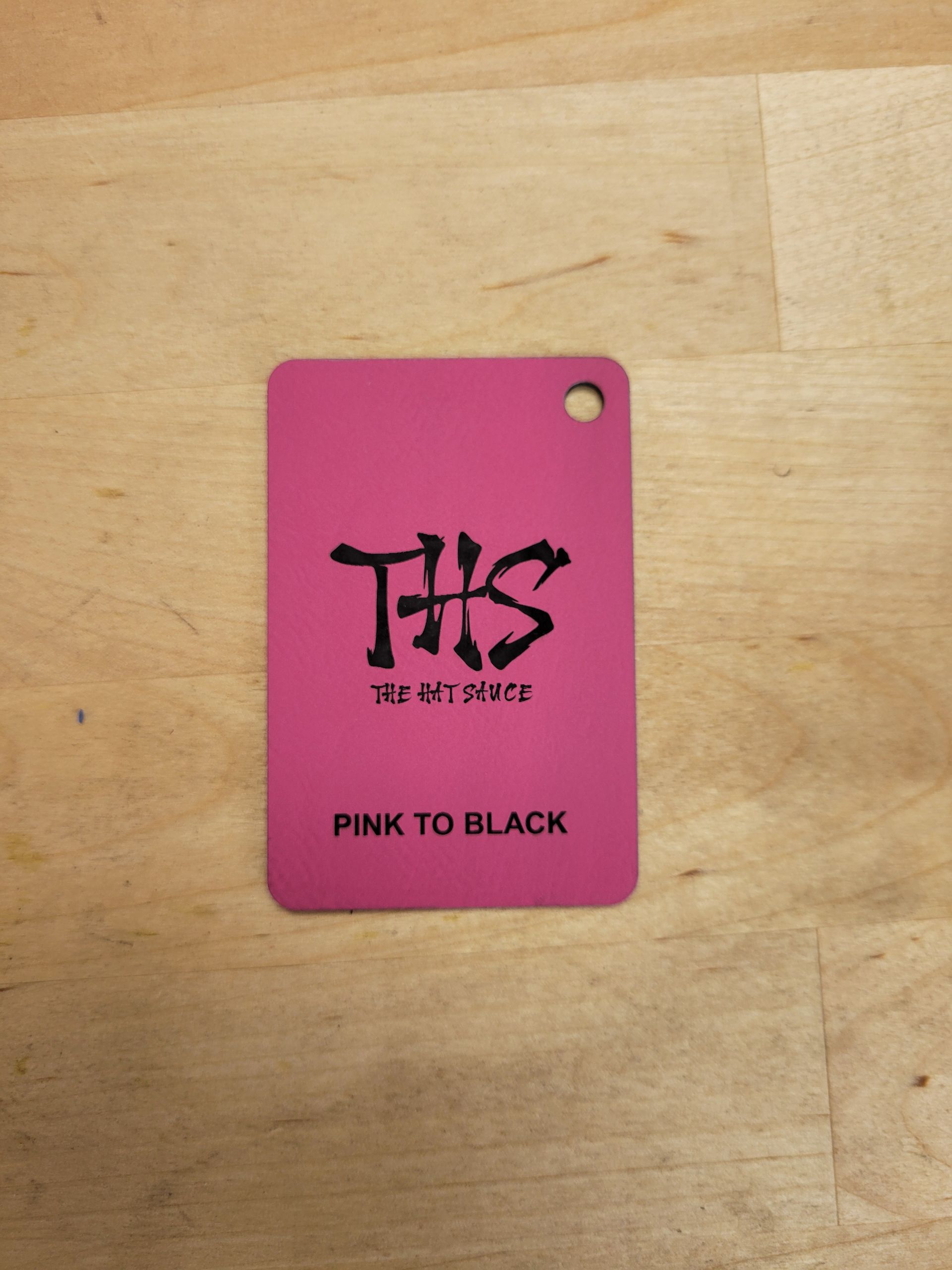 A pink tag that says pink to black on it