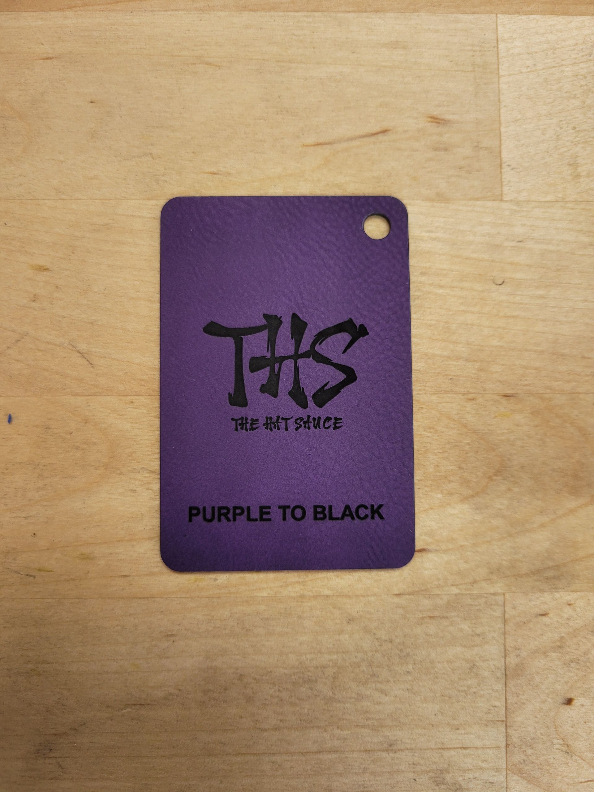A purple tag that says purple to black on it