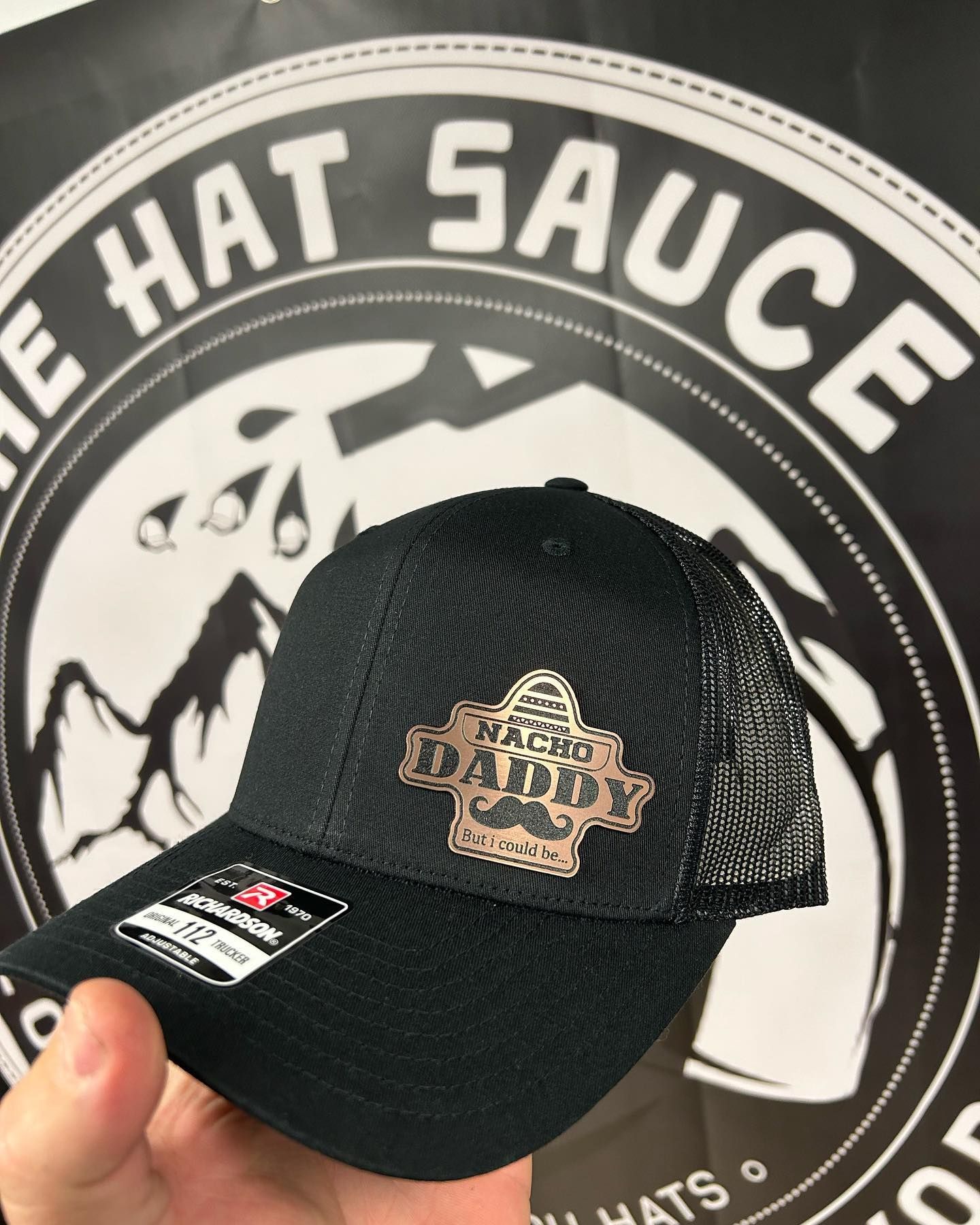 A person is holding a hat that says the hat sauce