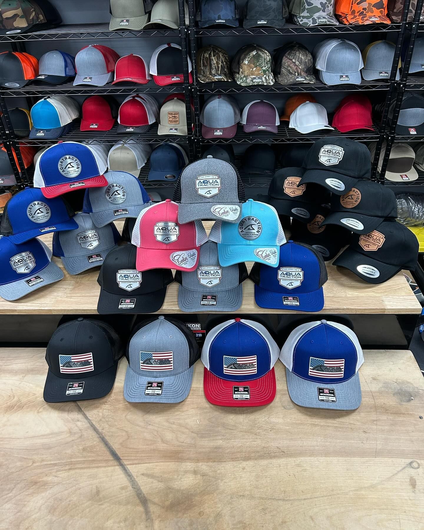 A bunch of hats are stacked on top of each other on a wooden table.