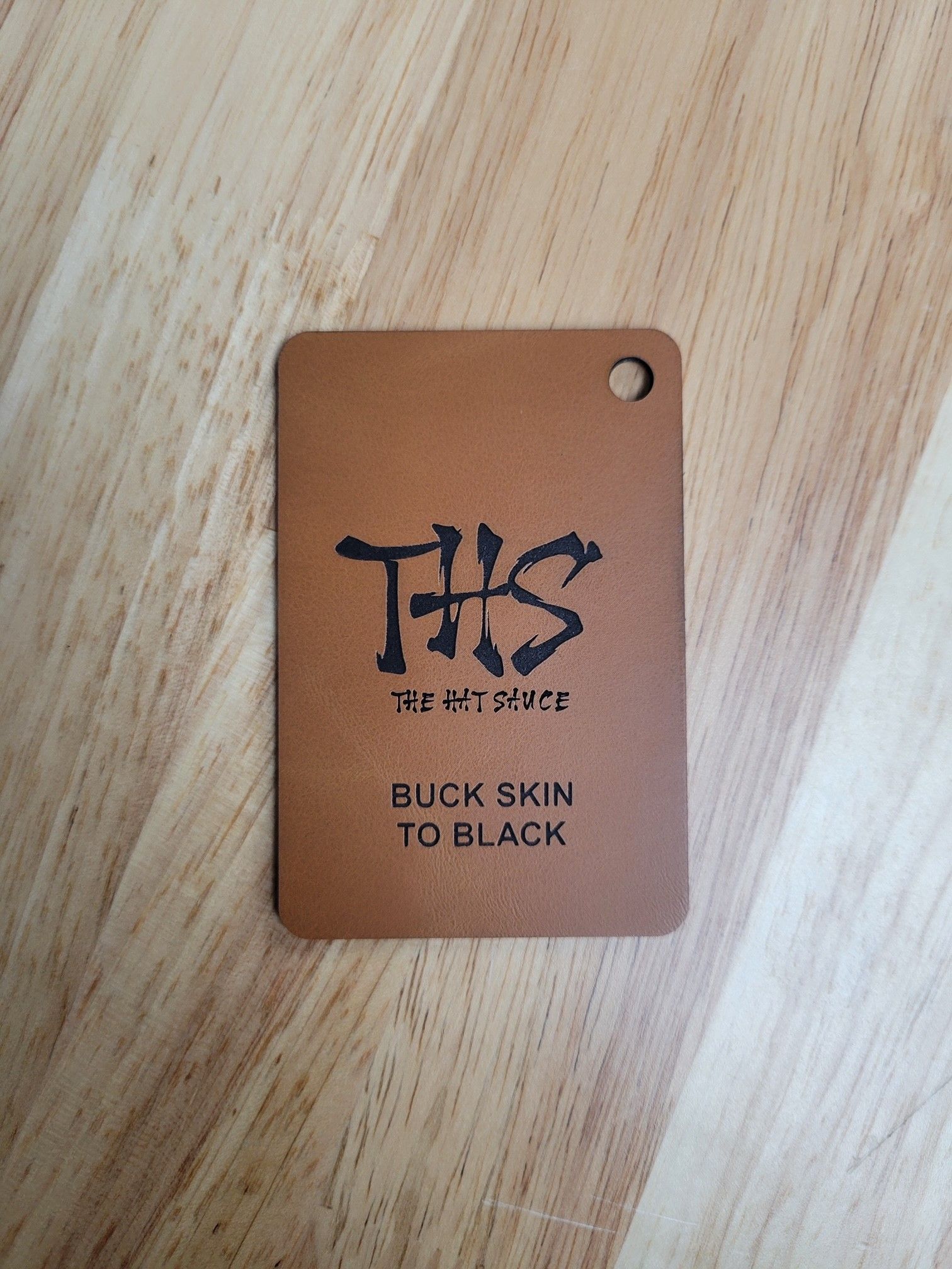 A brown tag that says this on it is on a wooden table