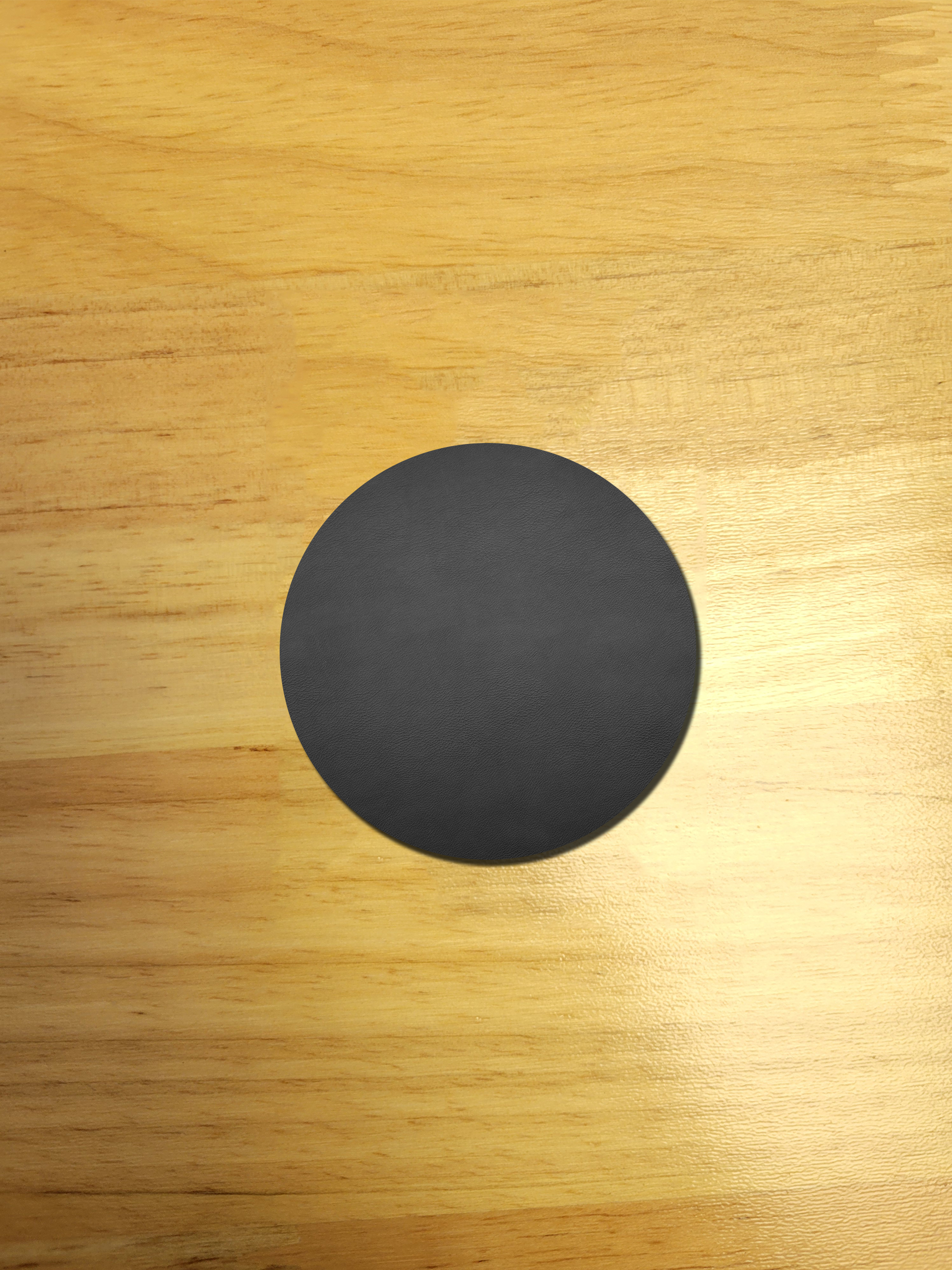 A black circle is sitting on a wooden surface.