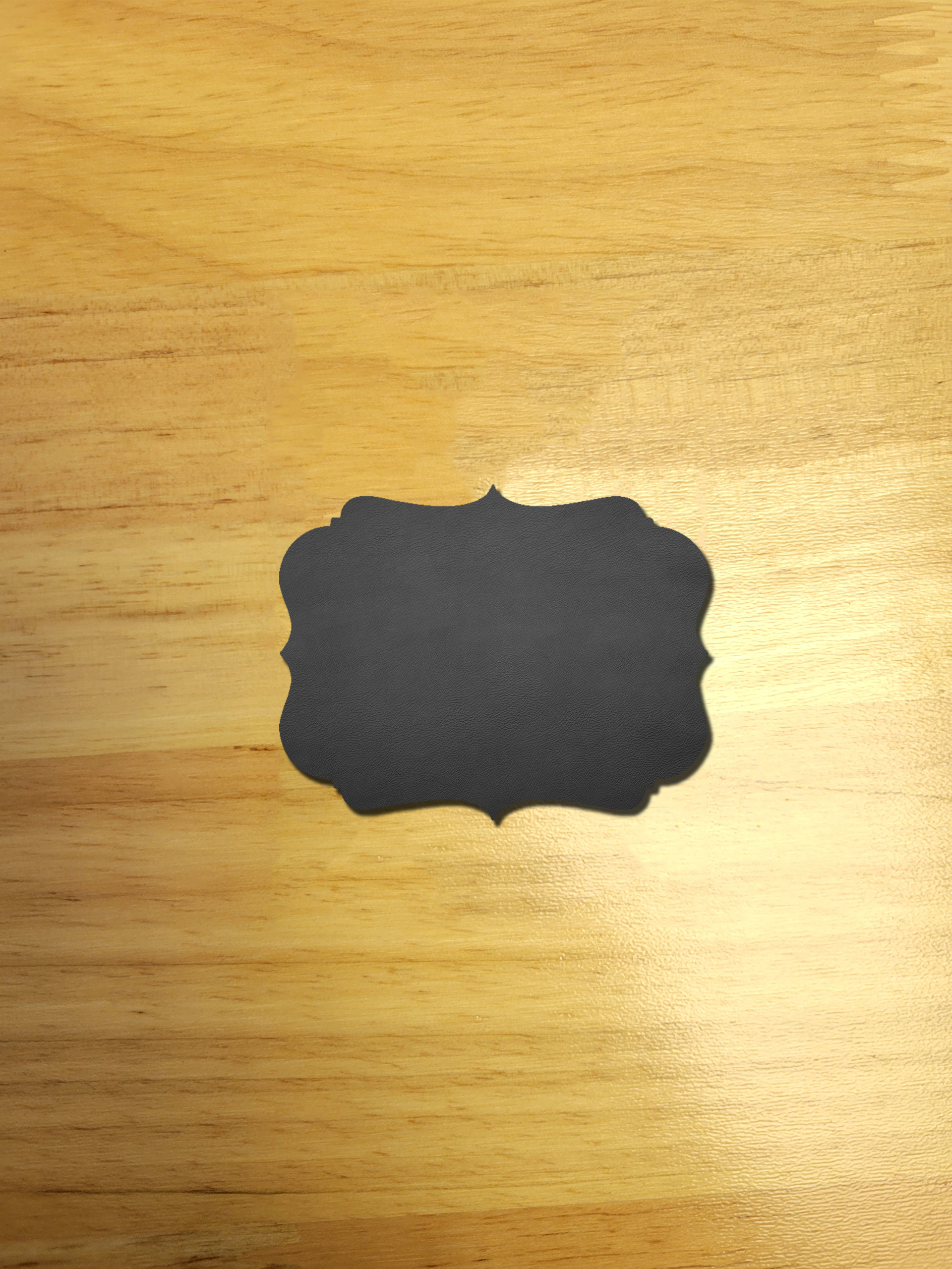 A black label is sitting on a wooden table.